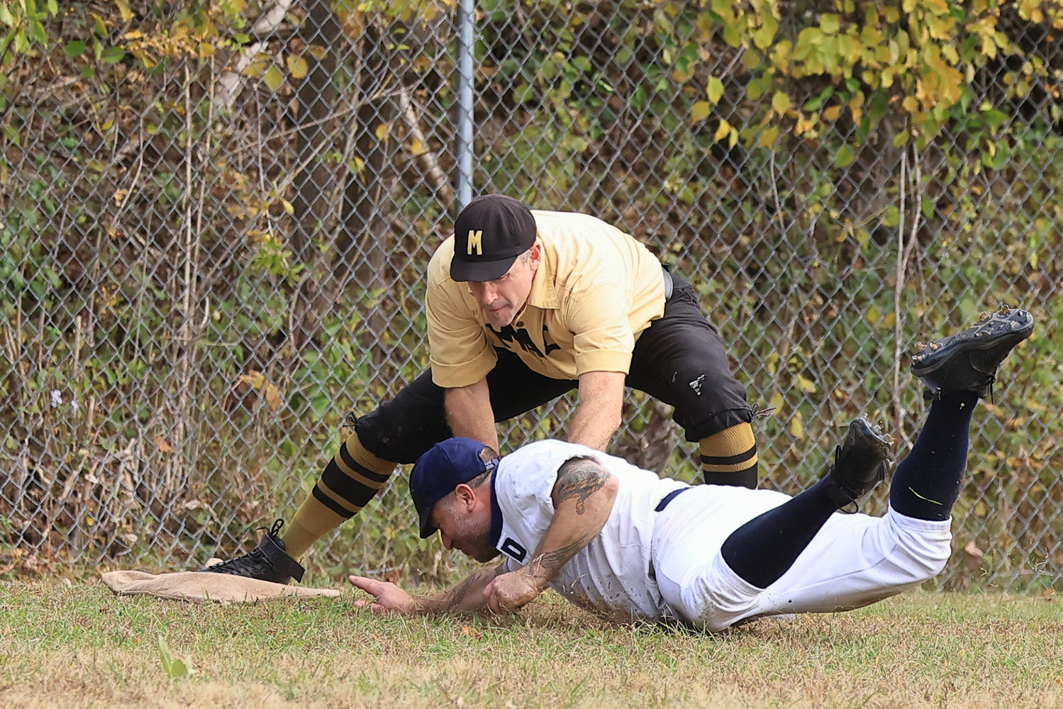 A Mountain Athletic Club third baseman puts the tag on the Delhi baserunner, as he slides into third base for an out.